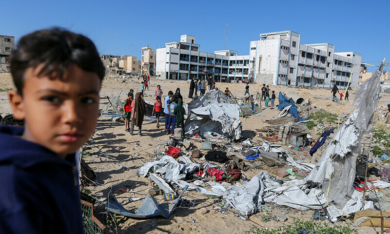 A child looks on as Palestinians inspect the site of an Israeli strike on a tent housing displaced people, in Khan Younis, in the southern Gaza Strip on March 19. &mdash; Reuters