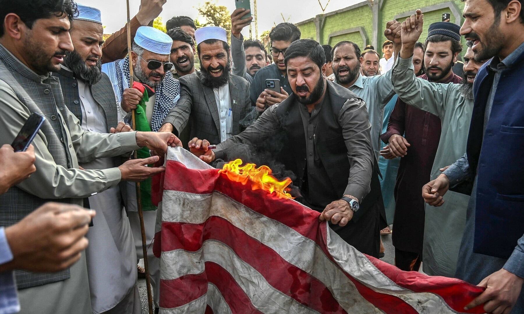 Members and activists of the Jamaat-i-Islami (JI) party burn US national flag during a protest outside US consulate, to express their solidarity with the Palestinians, in Peshawar on March 21, 2025. — AFP