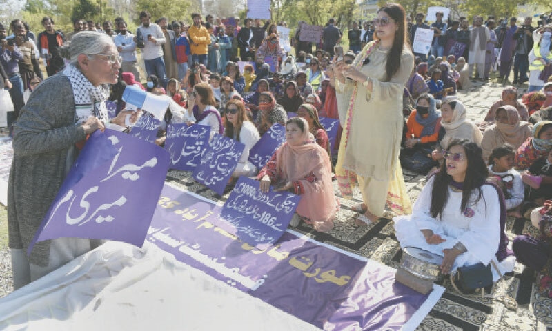 Rights activists hold banners during the Aurat March on the International Women’s Day outside the National Press Club in Islamabad on Saturday. — Photo by Tanveer Shahzad