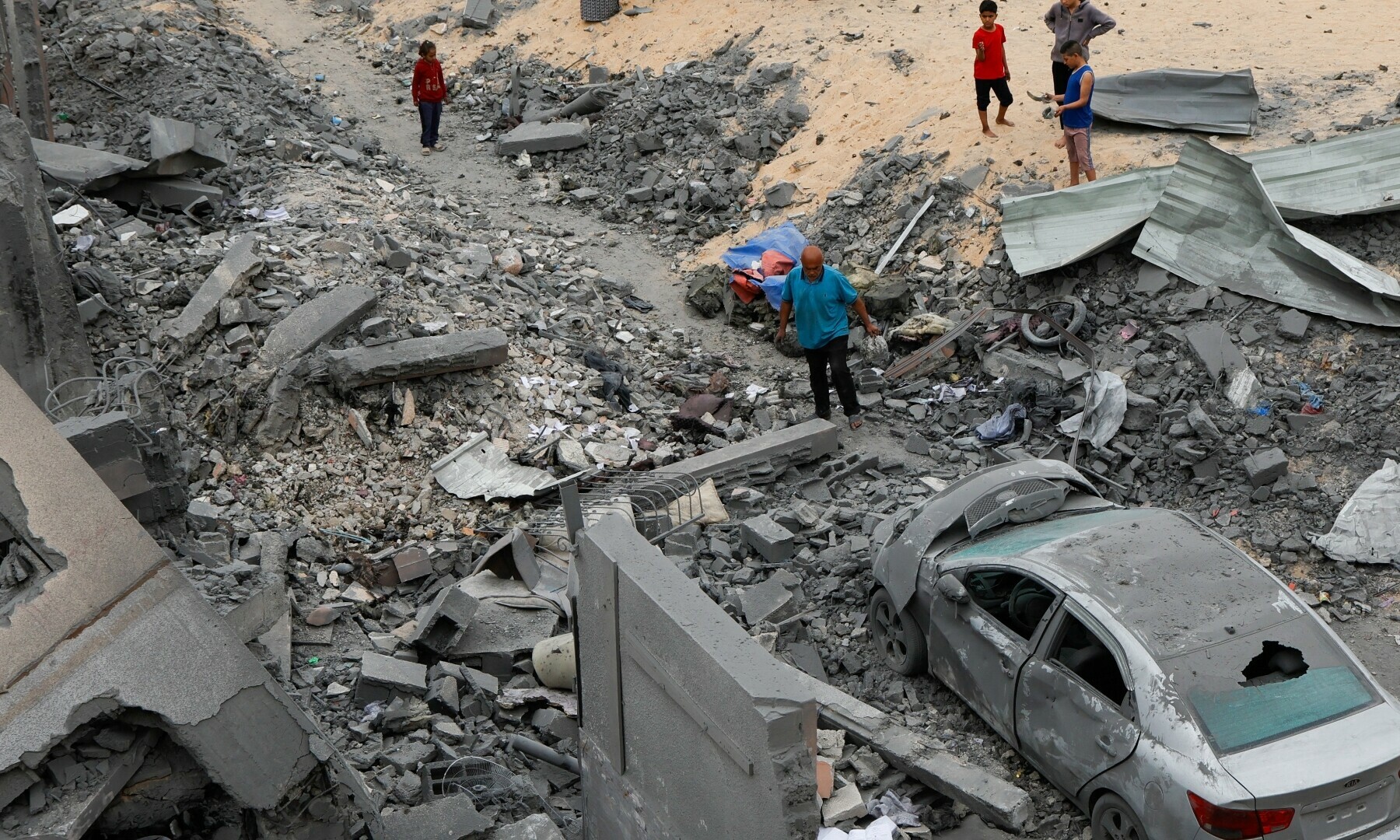  Palestinians inspect the site of an Israeli strike on a house in Khan Younis in the southern Gaza Strip on April 1, 2025. &mdash; Reuters/Hatem Khaled 
