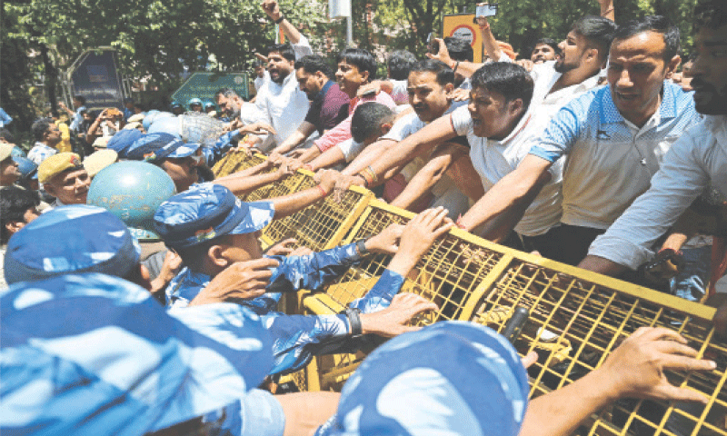 بھارتی سیکیورٹی اہلکار نئی دہلی میں پاکستانی قونصل خانے کی جانب بڑھنے والے مظاہرین کو روک رہے ہیں &mdash; فوٹو: اے ایف پی