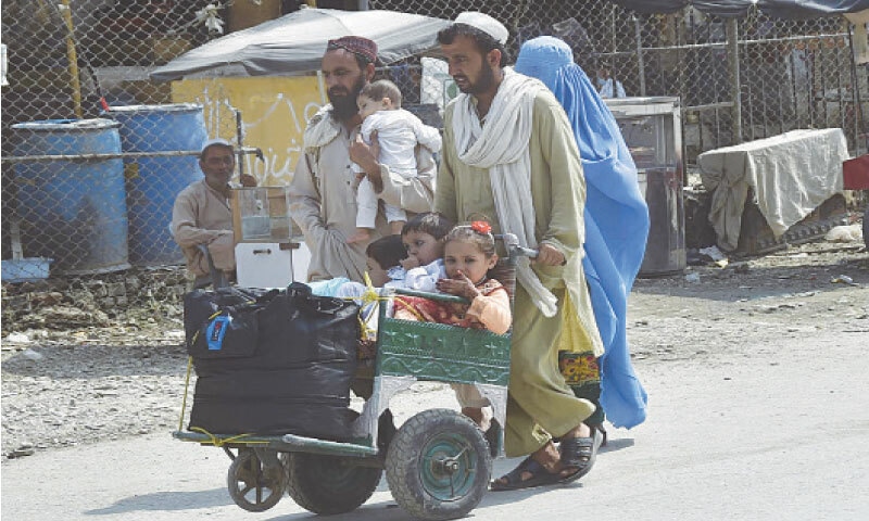 An Afghan family going back home at Torkham border. &mdash; INP