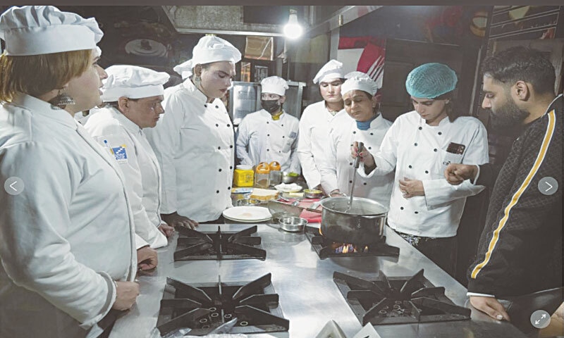 Zoya Khan, in the green fishnet cap, during a cooking class with fellow transgender students, including Neha Khan (left), under the supervision of their instructor, Chef Ali Haider (right), at the Culinary & Hotel Institute of Pakistan in Lahore | AP