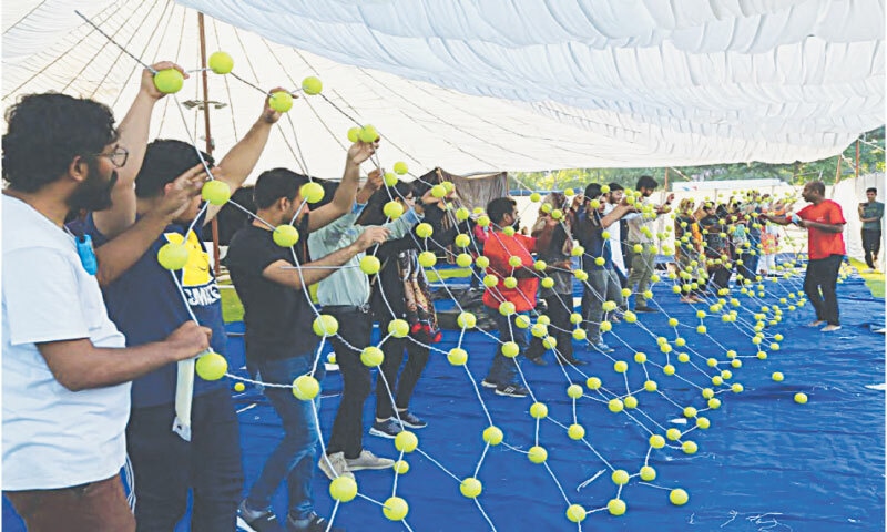 A team of volunteers helps set up a demonstration of molecular structure a day before the mela in 2023