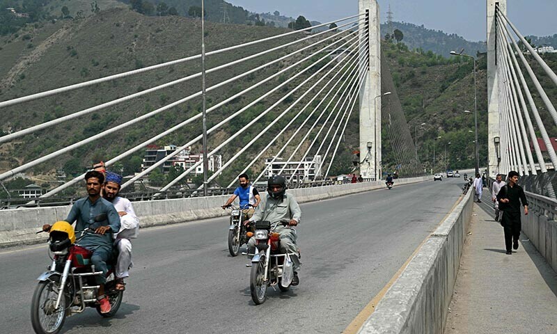 Commuters make their way along a bridge in Muzaffarabad on May 1, 2025. — AFP