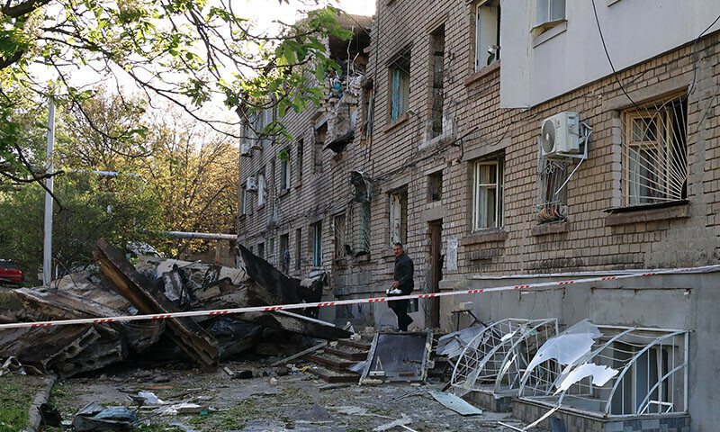 A local resident takes his belongings out of a damaged residential building after a drone attack in Zaporizhzhia, Ukraine on May 2. — AFP