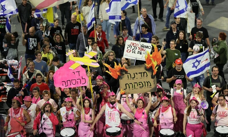 Demonstrators raise placards and Israeli flags during an anti-government protest calling for action to secure the release of Israeli hostages in front of the Israeli Defence Ministry in the coastal city of Tel Aviv on May 3. — AFP
