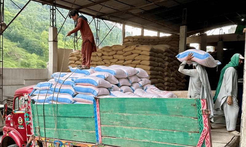 Labourers load sacks of wheat flour onto a truck at a mill on the outskirts of Muzaffarabad on Saturday for dispatch to Neelum valley’s Halmat village, as part of the AJK government’s effort to bolster food supplies in vulnerable areas along the LoC amid heightened tensions with India. — Photo by Tariq Naqash