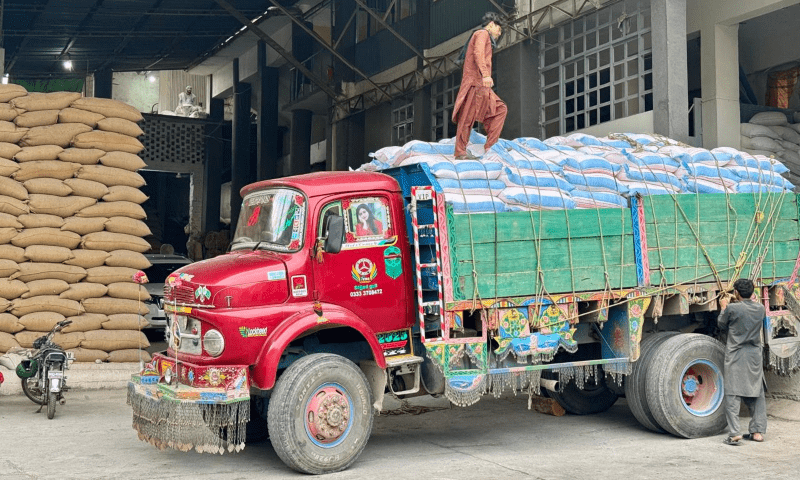 Workers secure sacks of wheat flour with ropes atop a truck at a mill on the outskirts of Muzaffarabad on Saturday before its dispatch to Neelum valley’s Halmat village, as part of the AJK government’s effort to bolster food supplies in vulnerable areas along the LoC amid heightened tensions with India. — Photo by Tariq Naqash