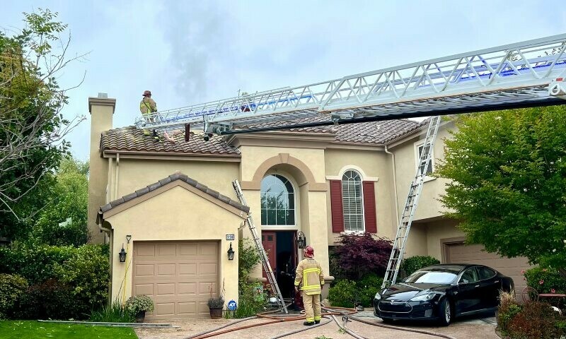 Firefighters stand on top of a house with holes in the roof — Photo by Ventura County Fire Department, posted on X.