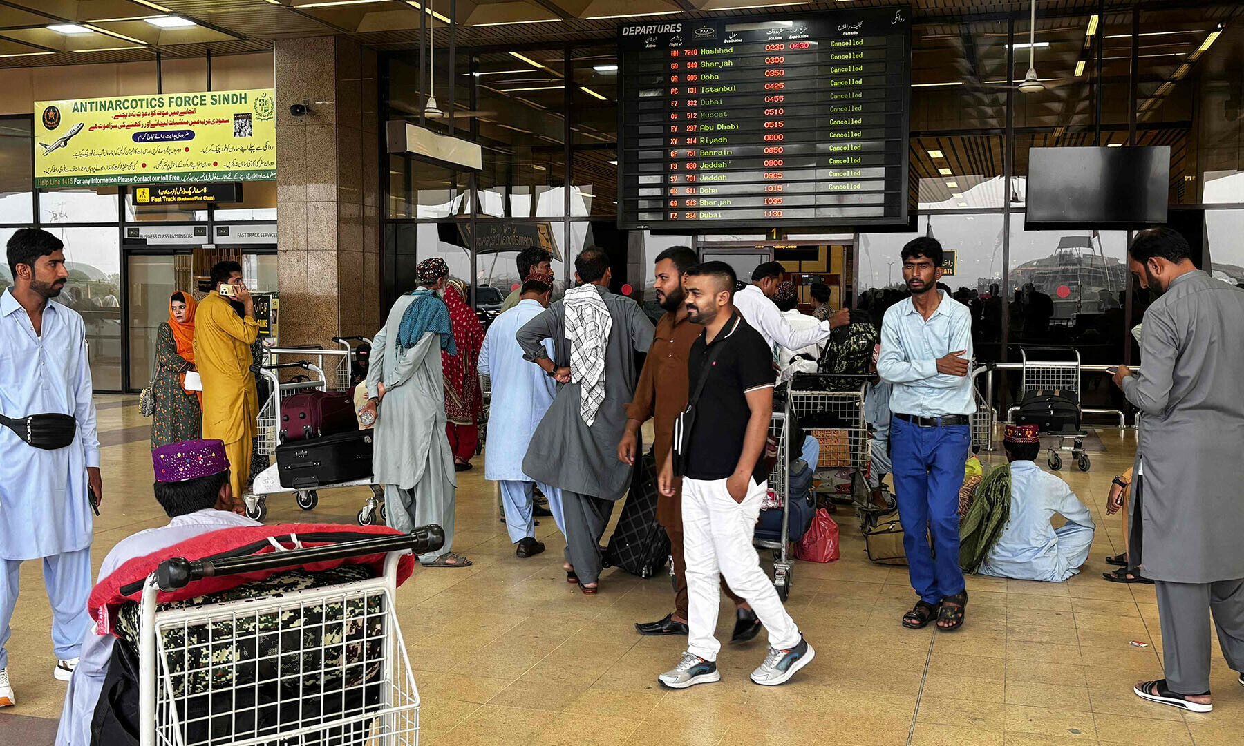 Passengers wait at Jinnah International airport after all domestic and international flights were cancelled in Karachi on May 7. &mdash; AFP