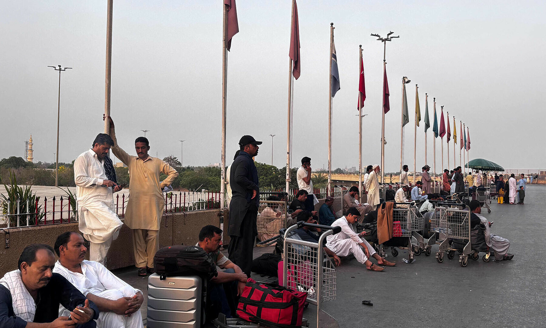 Passengers wait outside at Jinnah International airport after all domestic and international flights were cancelled in Karachi on May 7. &mdash; AFP