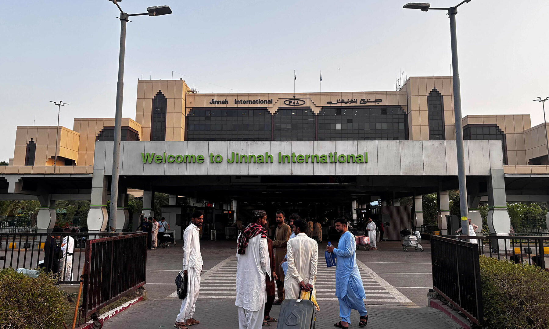 Passengers wait outside at Jinnah International airport after all domestic and international flights were cancelled in Karachi on May 7. &mdash; AFP
