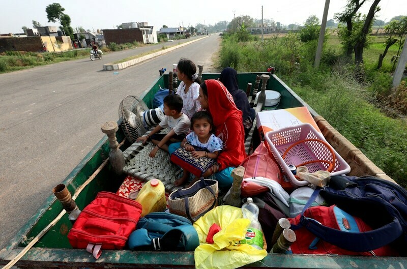 Villagers sit in a tractor trolley as they move to safer places as authorities evacuate residents living near the International Border (IB) with Pakistan, in Suchetgarh in occupied Kashmir, May 7. — Reuters