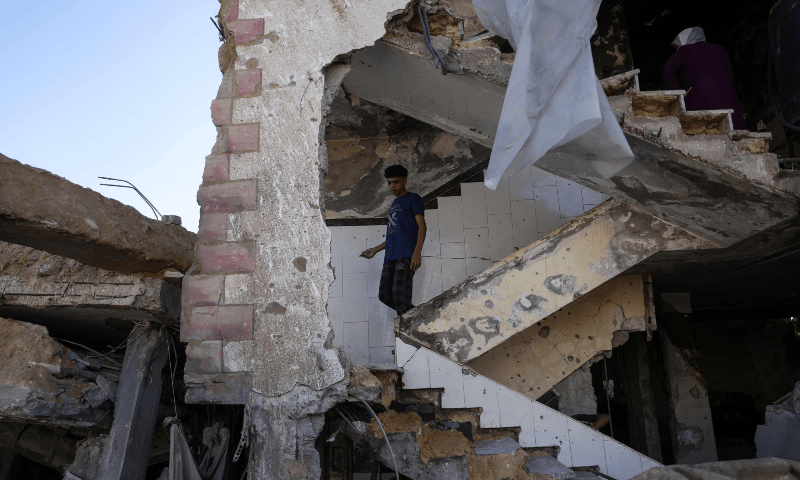  A young Palestinian walks down the stairs of a home in Jabalia in the Northern Gaza Strip after it was destroyed in an Israeli strike, on May 16, 2025. &mdash; AFP 