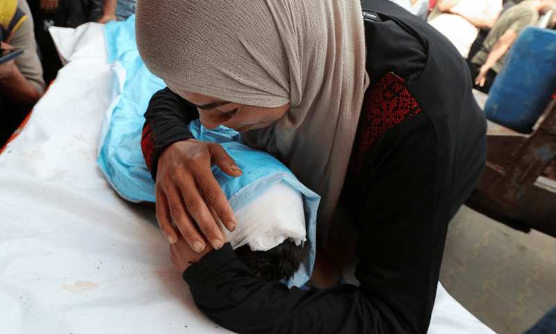  A mourner embraces the body of a Palestinian child killed in an Israeli strike, at Al-Aqsa Martyrs hospital, in Deir Al-Balah in the central Gaza Strip on May 18, 2025. &mdash; Reuters/Ramadan Abed 