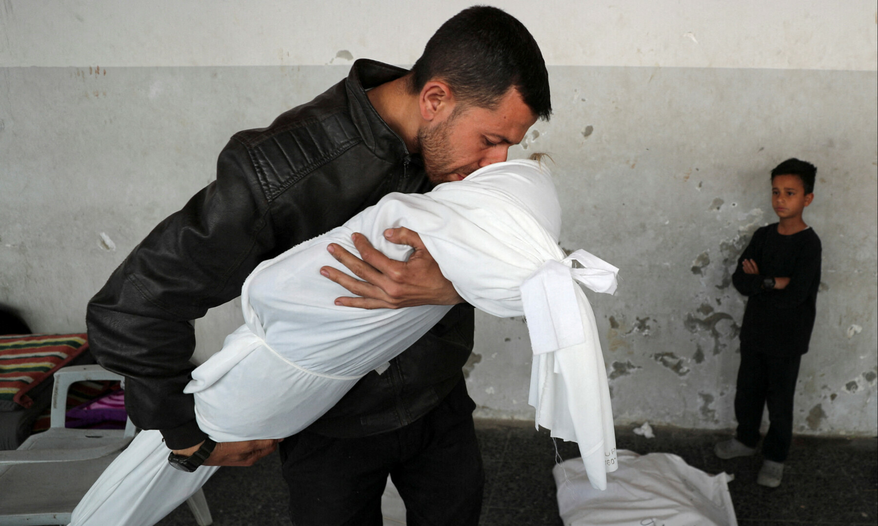 A Palestinian man kisses the body of his nephew Nour Nabhan, aged 5, who was killed in an Israeli strike, at Al-Ahli Arab Baptist hospital, in Gaza City on May 21, 2025. — Reuters/Mahmoud Issa