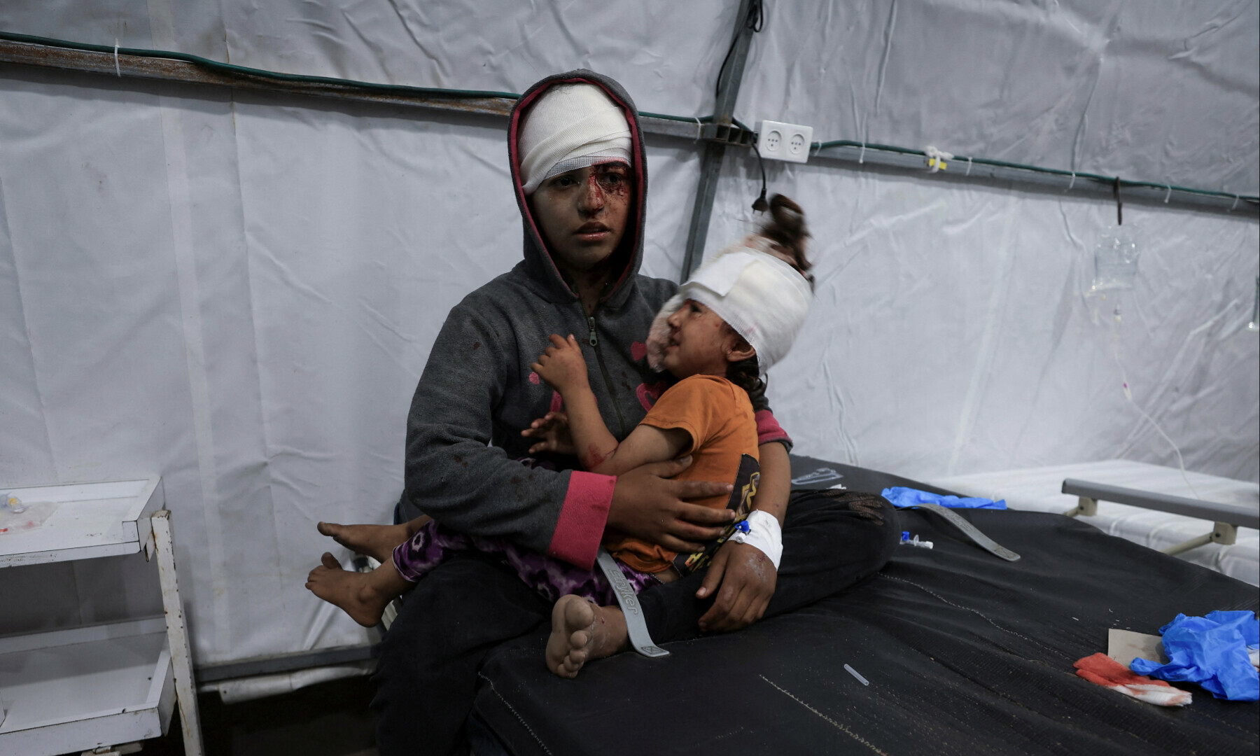 A wounded Palestinian sits while holding a child, at Al-Ahli Arab Baptist hospital, following an Israeli strike, in Gaza City on May 26, 2025. — Reuters/Dawoud Abu Alkas
