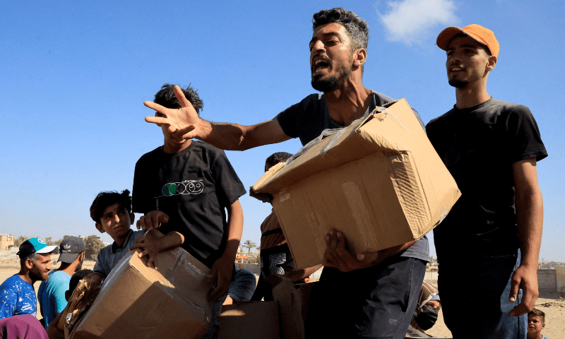 A person gestures as he carries a box as Palestinians gather near an aid distribution site run by the US-backed Gaza Humanitarian Foundation, in Rafah, in the southern Gaza Strip on May 27, 2025. — Reuters