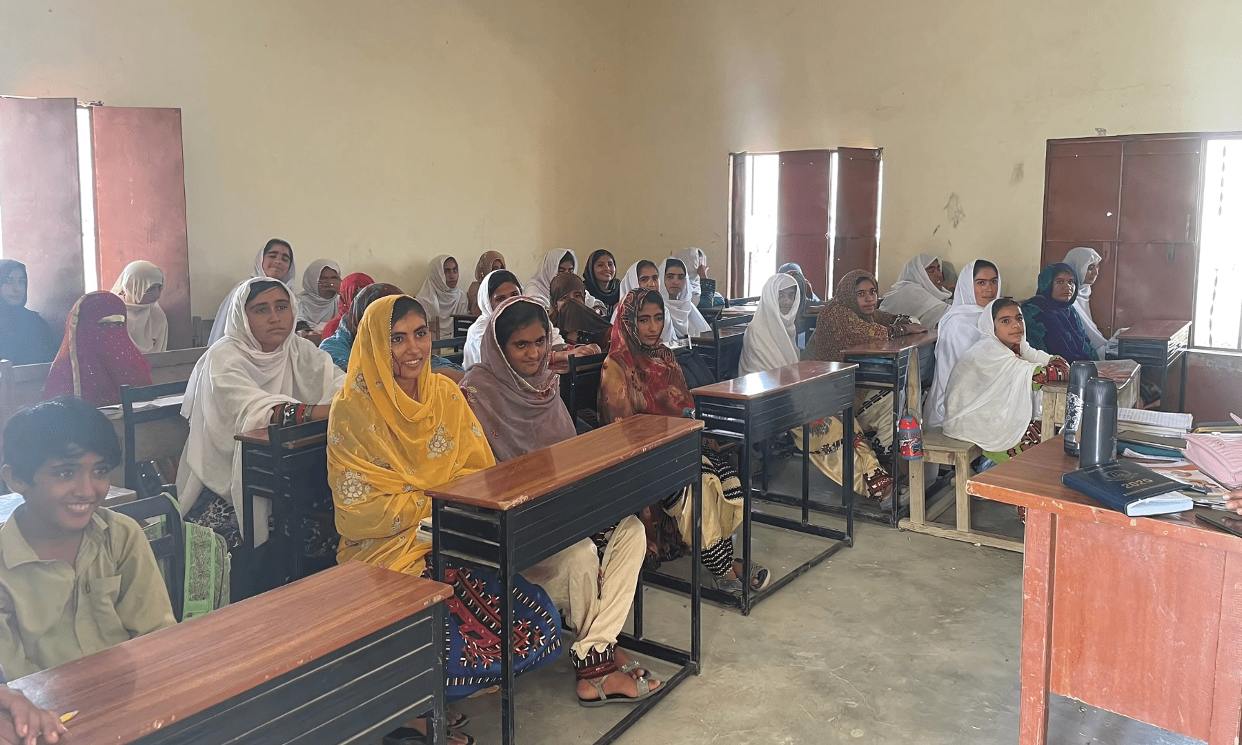 Students of all ages sit inside a classroom at a boys primary school in Dasht.