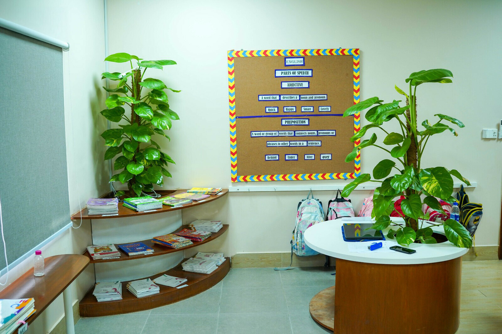 Two large plants in a brightly lit classroom at Alpha Prime.