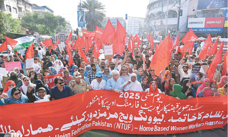 KARACHI: Participants in an International Labour Day rally pass through Saddar under blazing sun on Thursday.&mdash;PPI