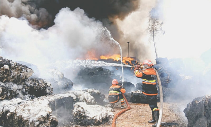 TOBA TEK SINGH: Firefighters try to extinguish a fire caught by cotton bales at a spinning mill on Khumanawala Road. — Dawn TOBA TEK SINGH: Firefighters try to extinguish a fire caught by cotton bales at a spinning mill on Khumanawala Road. — Dawn