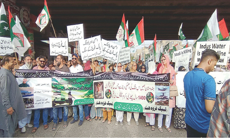 Rally participants hold banners and placards in Liaquatabad. &mdash;Dawn