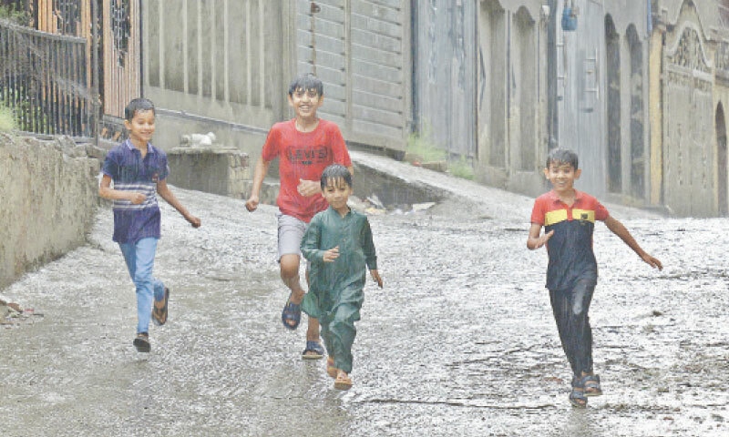 Boys play in the rain in a locality along Range Road in Rawalpindi on Sunday. &mdash; White Star