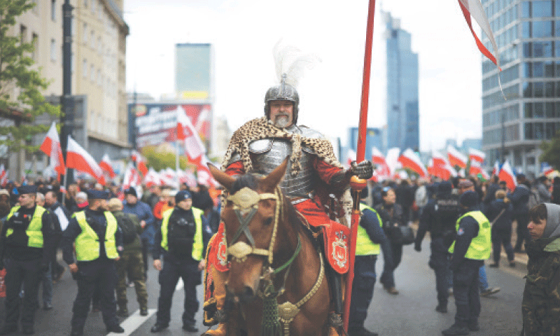 Warsaw: A man dressed as member of the Hussar, a heavy cavalry unit active from the 16th to 18th centuries, rides a horse as protesters take part in a march against immigration on Saturday.—Reuters