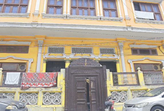 A wooden balcony with coloured glass work is the main feature of houses in the locality. — Photos by Mohammad Asim