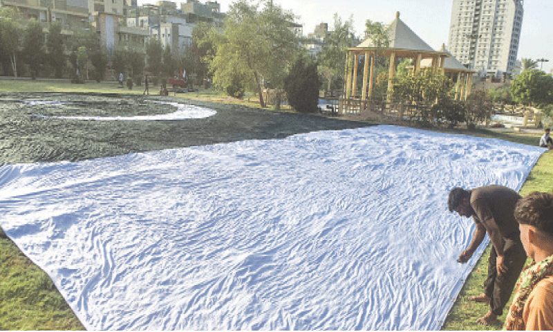 A workman inspects the national flag in a park.&mdash;Fahim Siddiqi / White Star