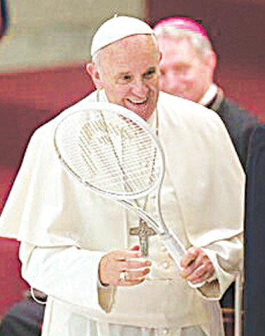 The late Pope Francis holds a tennis racket presented to him by the Italian Tennis Federation in 2015