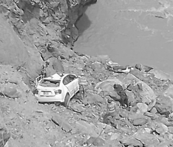 RESCUERS work near the mangled vehicle which fell into a gorge off Baltistan Highway in Skardu.—Photo by the writer
