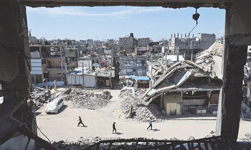 Palestinians walk near the rubble of houses in Khan Younis in the southern Gaza Strip on
March 27 | Reuters Palestinians walk near the rubble of houses in Khan Younis in the southern Gaza Strip on
March 27 | Reuters