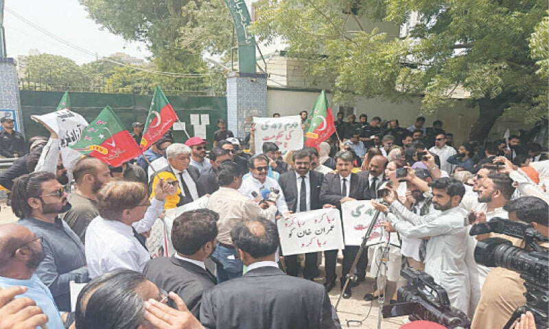 PTI’s Haleem Adil Sheikh speaks alongside other party leaders and workers.—Dawn