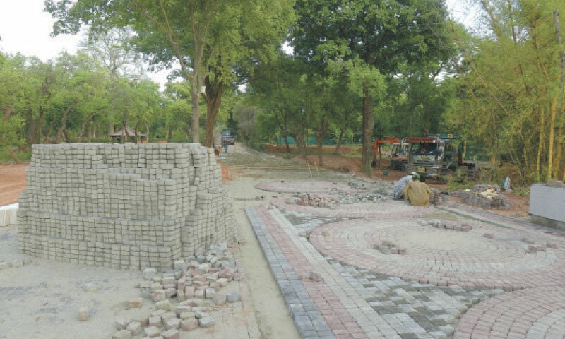 Labourers fix tiles at CDA&rsquo;s nursery on Park Road in Islamabad. &mdash; White Star