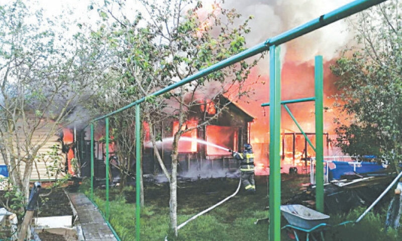 A firefighter works outside a burning house following a Ukrainian drone attack on a settlement in Moscow.—Reuters A firefighter works outside a burning house following a Ukrainian drone attack on a settlement in Moscow.—Reuters