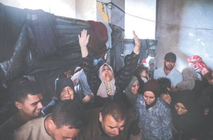 GAZA STRIP: Palestinians mourn members of the Azzam family who were killed in Israeli strikes on their home in central Jabalia, on Thursday. Rescuers said at least 44 people were killed as Israel intensified its bombardment across the besieged territory.—AFP