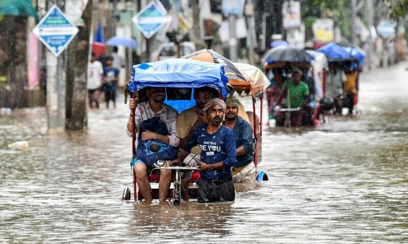 Residents commute in cycle rickshaws through a flooded street after heavy rains in Guwahati, in India’s Assam state on May 31. — AFP Residents commute in cycle rickshaws through a flooded street after heavy rains in Guwahati, in India’s Assam state on May 31. — AFP