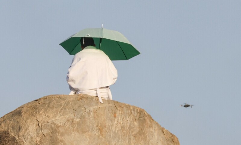  A surveillance drone flies past a Muslim pilgrim as he prays at dawn on Saudi Arabia’s Mount Arafat, also known as Jabal al-Rahma or Mount of Mercy, during the climax of the Haj pilgrimage on June 5. — AFP 