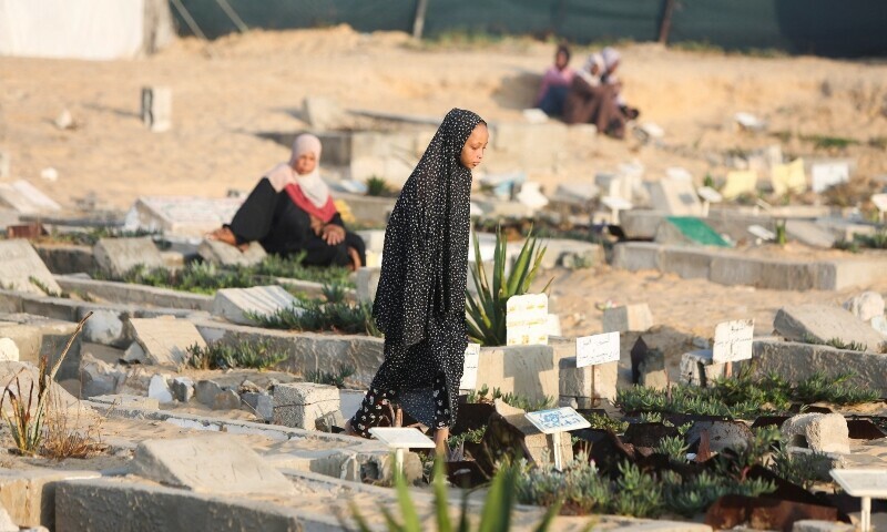 A Palestinian girl visits the grave of her relatives at a cemetery on the first day of Eidul Azha, in Khan Younis, in the southern Gaza Strip, June 6, 2025. &mdash; Reuters