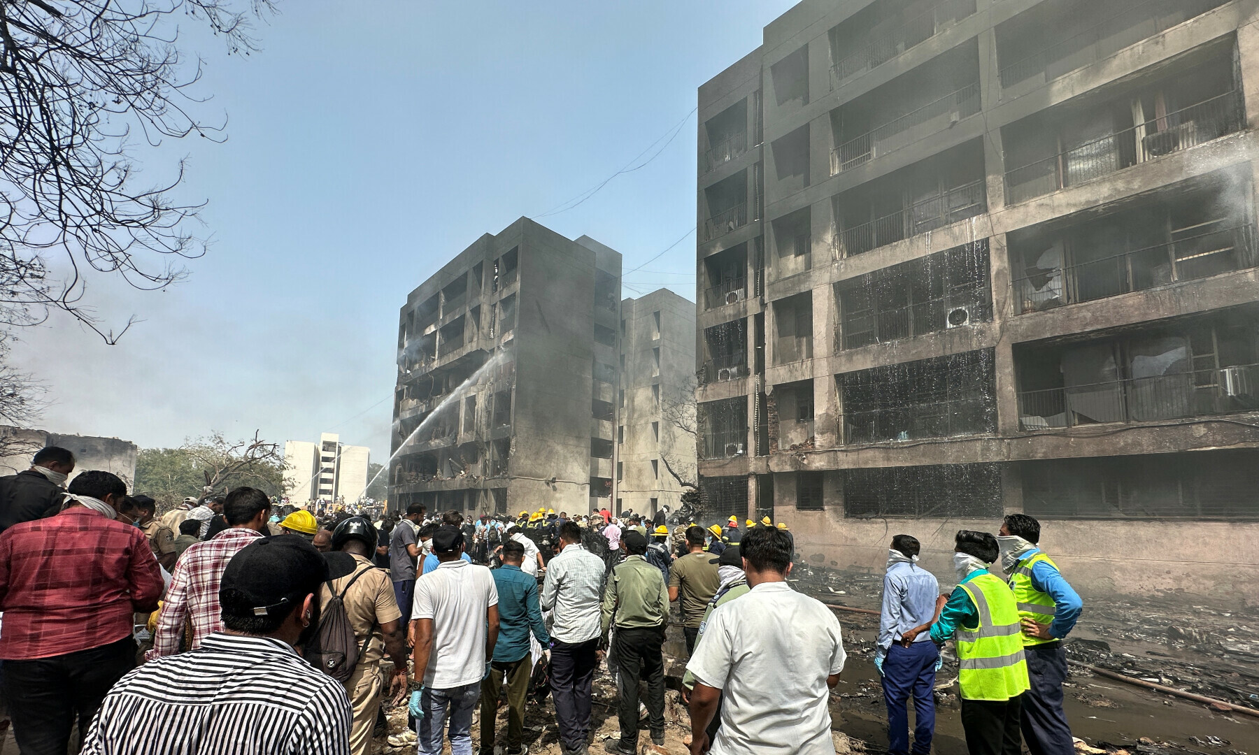 People gather near a damaged building at the site where an Air India Boeing 787 Dreamliner plane crashed in Ahmedabad, India on June 12, 2025. — Reuters/Amit Dave