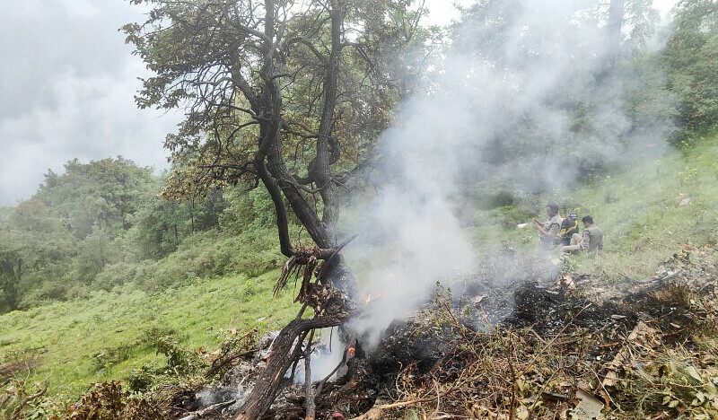 This handout photograph released by the State Disaster Response Force of India’s Uttarakhand state shows smoke billowing from the site of a chopper crash near Gaurikund on  June 15. — AFP