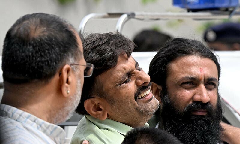 A family member (C) mourns the death of an Air India flight crash victim as he arrives to collect mortal remains outside a hospital mortuary in Ahmedabad on June 15. — AFP