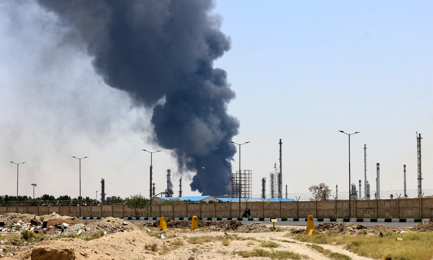 A plume of heavy smoke and fire rise over an oil refinery in southern Tehran, after it was hit in an overnight Israeli strike, on June 15. — AFP