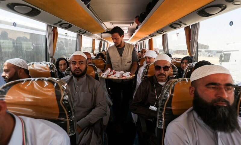 Iranian pilgrims who were rerouted through Iraq sit inside a bus after being unable to fly home due to the ongoing conflict.—Reuters