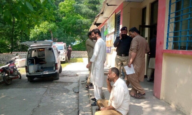 Rescue officials and police stand outside the hospital in Mansehra, June 20. —  Rescue 1122