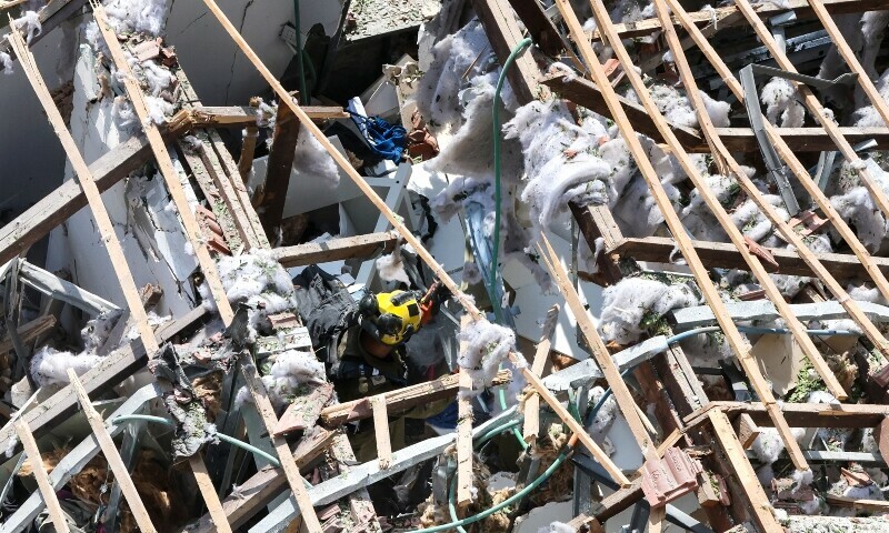 A member of Israel&rsquo;s security forces inspects the damage at the site of an Iranian strike that hit a residential neighbourhood in the Ramat Aviv area in Tel Aviv on June 22. &mdash; AFP