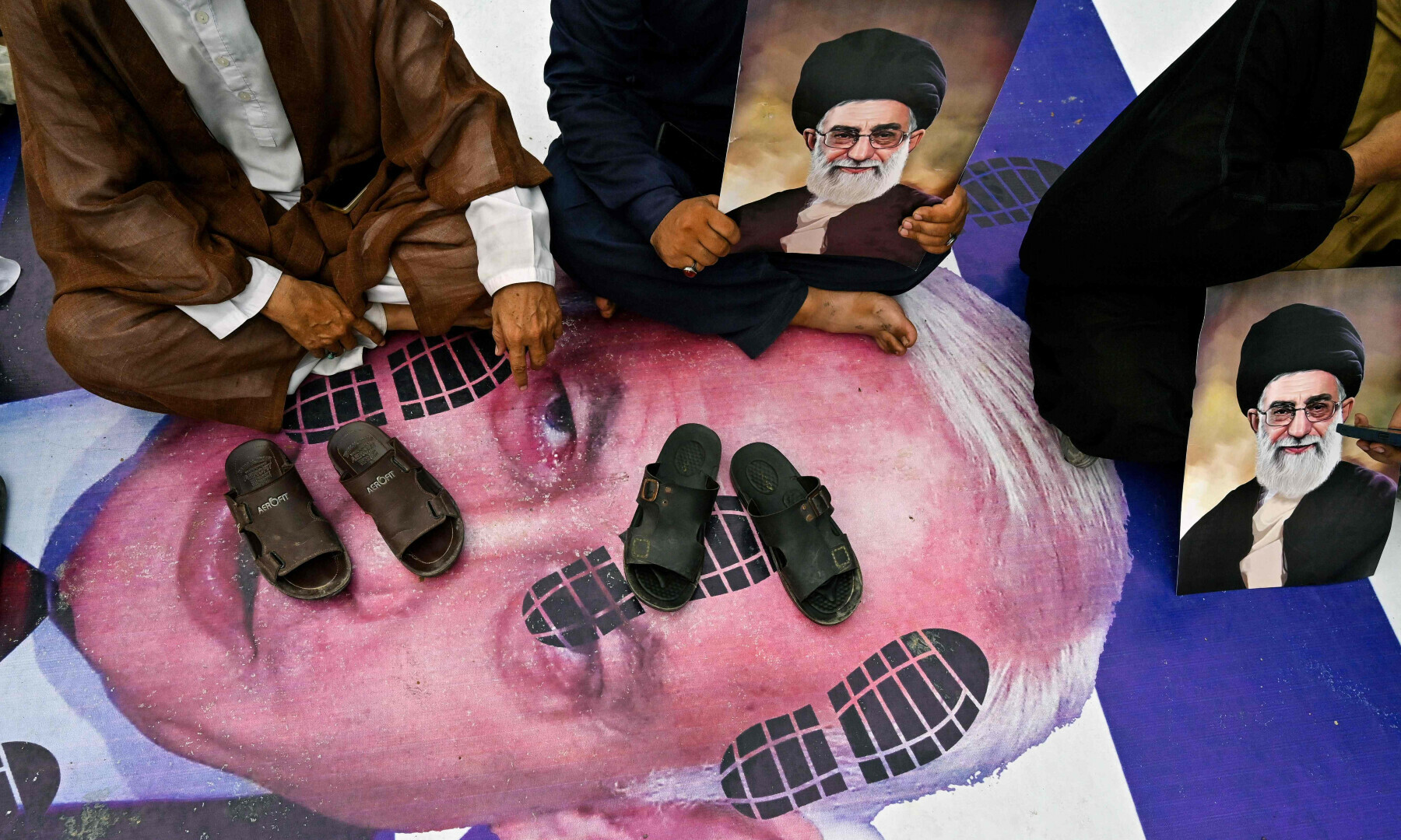  Protesters hold portraits of Iran&rsquo;s Supreme leader Ayatollah Ali Khamenei as they lay their shoes over a poster of Israel&rsquo;s Prime Minister Benjamin Netanyahu to condemn US and Israel&rsquo;s attacks on Iran, during a protest in Karachi on June 22, 2025. &mdash; AFP 